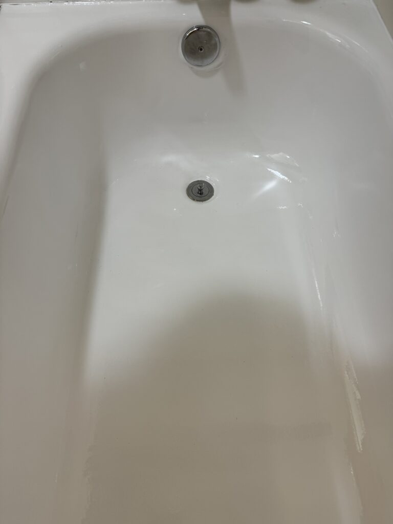 Empty white bathtub with drain plug.